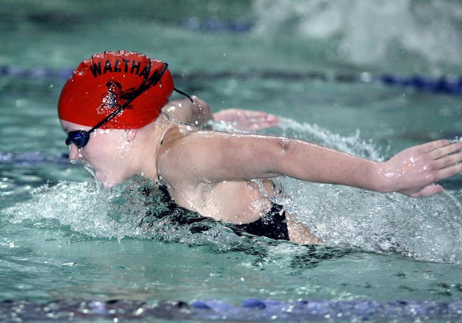 Waltham sophomore Jenny Doolin swims to victory in the 200-yard individual medley during yesterday's meet against Cambridge at Brandeis University.
