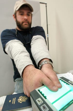 Stewart Johnston, with Moran Towing, a tugboat company serving the State Port, has his thumbprints scanned Monday.