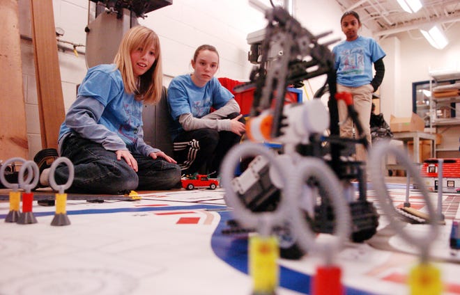 Devin Doyle, 13, Ali Crooker, 13, and Nyshida Gurijala, 11, (left to right) of the RoboLancers watch their robot "Steve" run through its programs, Tuesday afternoon at the Luther Burbank Middle School in Lancaster.