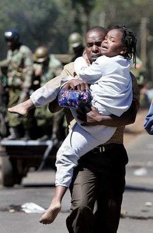 AP Photo
A young girl cries as she is carried by a man fleeing an area of wooden kiosks which was set on fire by supporters of Raila Odinga's party, the Orange Democratic Movement (ODM), in the Kibera slum area of Nairobi, Kenya on Thursday. Riot police fired tear gas and water cannons Thursday to beat back surging crowds of rock-throwing opposition protesters who took to the streets in a mass rally many feared would deepen the crisis wracking what had been one of Africa's most stable country's.