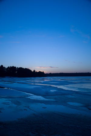 The sun sets on Lake Massapoag in Sharon, creating a variety of blue hues.