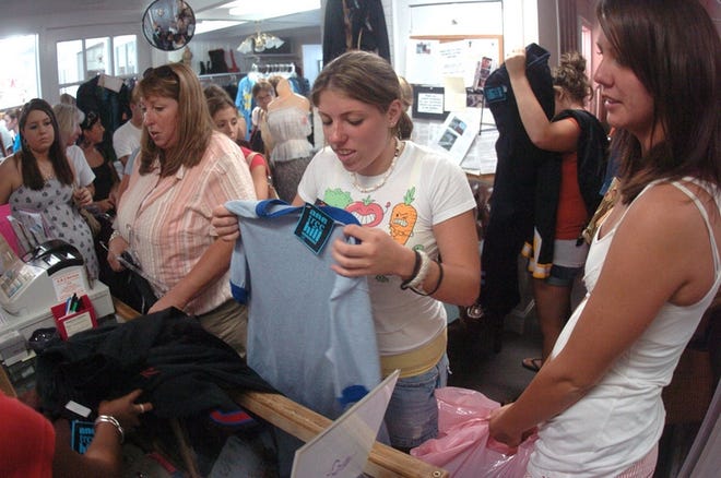Allison Tamney, center, Tamney's mother Joann Tamney, left, and her cousin Victoria Councilman pay for some of their many purchases at the One Tree Hill wardrobe sale at the Bargain Box in Wilmington Saturday, August 18, 2007. The Tamney's traveled from Long Island and Councilman traveled from Greensboro.  Staff Photo By Matt Born/Wilmington Star-News.