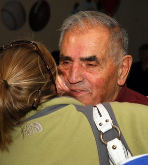 Natick's Vangie Sticka receives a hug from an attendee of his 80th Birthday party at the Natick Elks Lodge.
