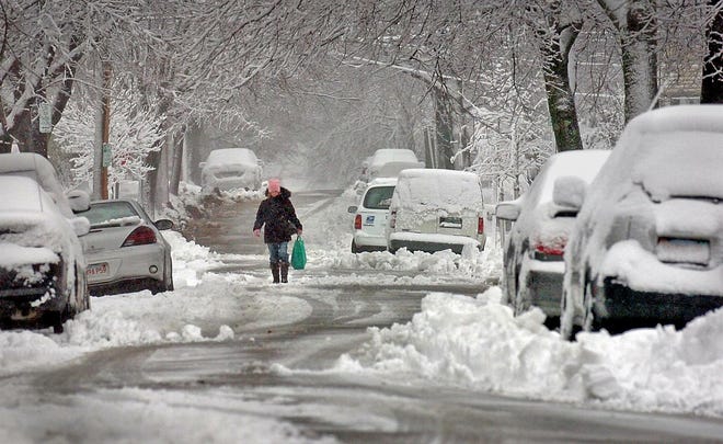 A pedestrian negotiates a snow-covered street in Quincy.