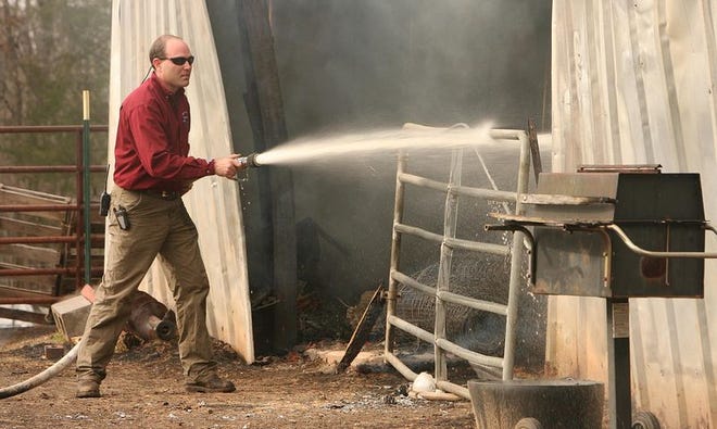01-15-08- Tuscaloosa, Ala- Coker Volunteer fire fighter Steve Hysaw sprays water on a fire that destroyed the barn and killed at least two horses belonging to Tuscaloosa veterinarian Douglas Shaver Tuesday January 15, 2008 in the Sipsey Valley area of West Tuscaloosa County.(Michael E. Palmer/Tuscaloosa News)