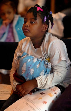 Tanieya Barr, 6, of Framingham listens to high school students speak at the conclusion of the Greater Framingham Community Church's Martin Luther King Jr. Youth Conference at Framingham State College Saturday.