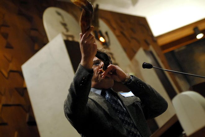Rabbi Alfred Benjamin blows the traditional shofar, or ram’s horn, to begin an interfaith celebration of the Rev. Martin Luther King, Jr.’s birthday at Temple Shalom in Milton.