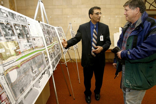 Masood Ahmad (left), a project engineer for the Illinois Department of Transportation, talks with Richard Genovese, who owns property that will be directly affected by the announcement of the expansion of West State Street west of Rockton Avenue in Rockford. The open house was held at the Crusader Clinic on West State Street on Jan. 24, 2008.