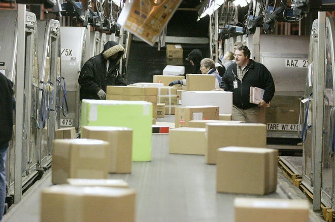 UPS workers handle outgoing packages Nov. 28 at the hub in Rockford.