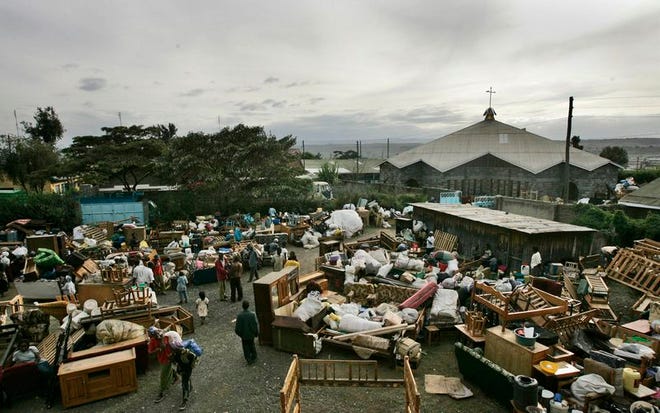 Furniture and other belongings fill the yard of a church where dozens of families who had their houses burned down, or fled for safety, are now living, in Nakuru, Kenya, Saturday, Jan. 26, 2008. Gunfire erupted in the town and young men vowed revenge as the death toll from two days of bloodshed in western Kenya's main town reached at least 25, including 16 charred bodies unloaded at the morgue from the back of a truck. (AP Photo/Ben Curtis)
