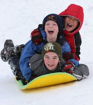 Alex Thompkins, 10, Connor Welch, 8, and Kevin Nguyen, 7, sled in their neighborhood in Dover on Sunday afternoon.