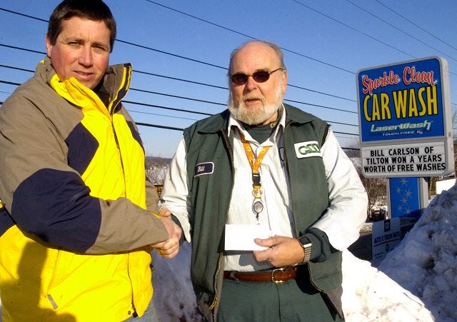 STEPHEN MITCHELL, left, owner of Sparkle Clean Car Wash in Laconia, presents Bill Carlson of Tilton with a certificate for a year's worth of car washes after wining the local contest.