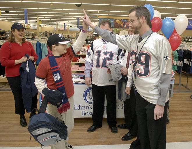 David Youngerman, 10, of Hudson, gets a high-five from Wal-Mart's Mike Albro before heading out on a $500 shopping spree at the Hudson Wal-Mart on Thursday. Youngerman and his mother, Michelle Marengo, left, will attend Super Bowl XLII in Arizona.