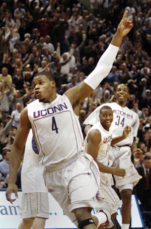 Connecticut's Jeff Adrien (4) celebrates after his team's 69-67 basketball win over Louisville in Hartford, Conn., on Monday, Jan. 28, 2008. In the background are teammates Hasheem Thabeet and Curtis Kelly (34).