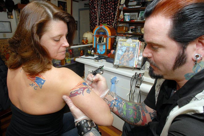 Lisa Laflamme, 44, of Norwich got two New England Patriots tattoos from Adam Hillyer at the Eagle's Nest Tattoo Studio in Norwich.