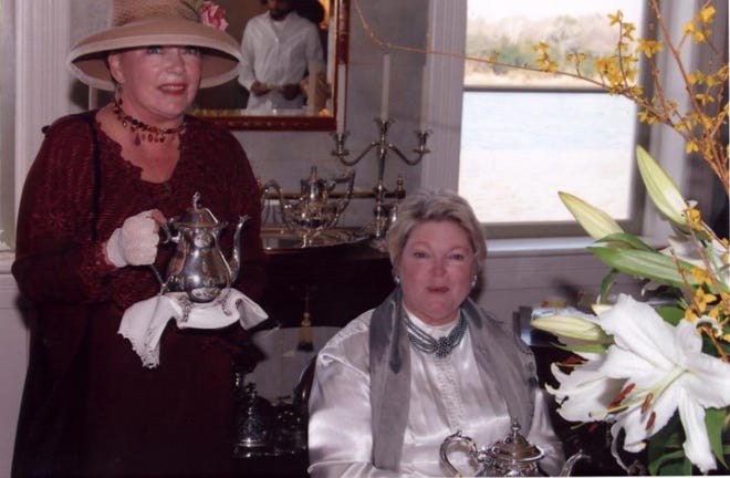 Patricia Silver, right, and Leslie Sandlin offer tea to guests.