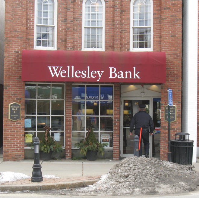 An officer outside the Wellesley Bank on Central Street at about 10:30 this morning following a reported robbery.