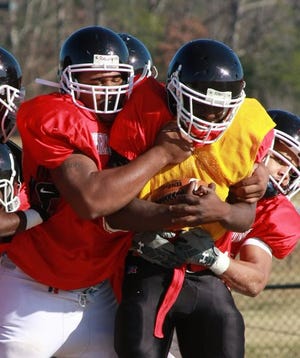 Newberry's Kenny Davis, left, assists on a tackle at Shrine Bowl practice in December.