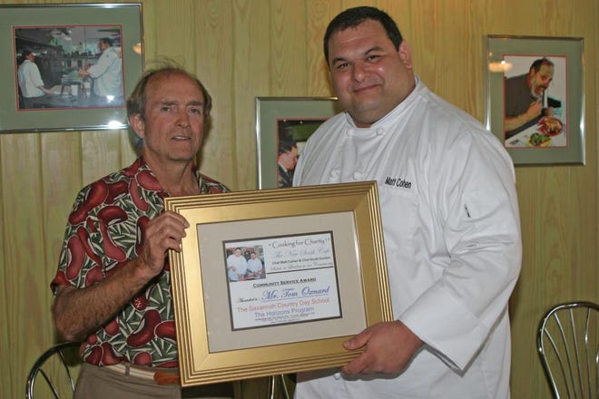 Tom Oxnard, left, accepts a framed Community Service Award from the New South Cafe's Chef Matt Cohen. Oxnard played a big part in supporting "Cooking for Charity!," an event that also rasied money and awareness for nonprofit organizations and those in need.