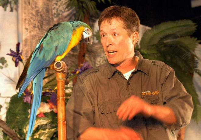 Michael Kohlrieser, owner of Understanding Wildlife Inc., an Ohio-based nonprofit, works with a parrot during his “Live on Stage, the Rain Forest” program at South River Elementary School in Marshfield on Wednesday.