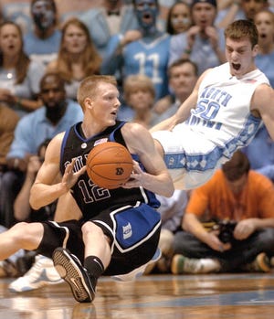 Duke's Kyle Singler, left, falls to the floor as North Carolina's Tyler Hansbrough (50) defends during the first half of a college basketball game in Chapel Hill, N.C., Wednesday, Feb. 6, 2008. (AP Photo/Sara D. Davis)