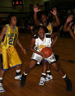 Mia Ready of Groves keeps possession of the ball despite tenacious defense from Monique Willis, left, and Khalilah Watson of Beach.