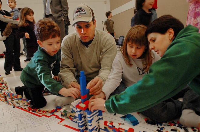 The Rosenthal family of Framingham, from left Nathan, 6, father Jonathan, Sarah, 11, and mother Susan, build a replica of the Damascus Gate out of Legos as part of a group project to build a model of the city of Jerusalem yesterday at Temple Beth Am in Framingham. The two-hour project, presented by Building Block Workshops of Livingston, N.J., included a talk by architect Stephen Schwartz about the city.