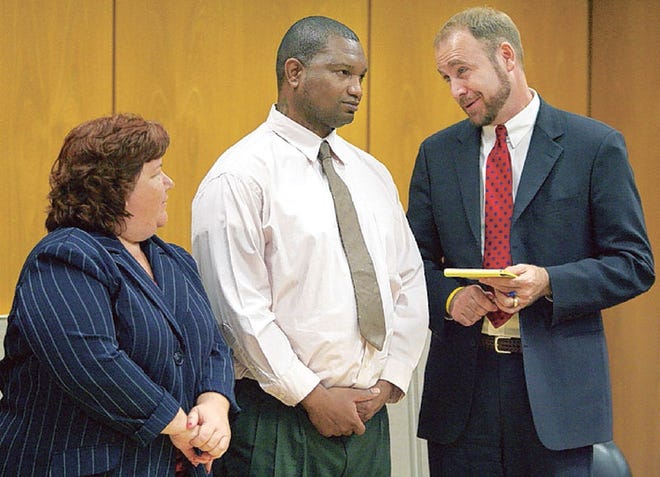 TIMOTHY McELRATH, center, confers with his lawyers, Julia Williamson and David Carmichael, in Circuit Judge Dennis Maloney's court on Tuesday. McElrath is accused of murder.