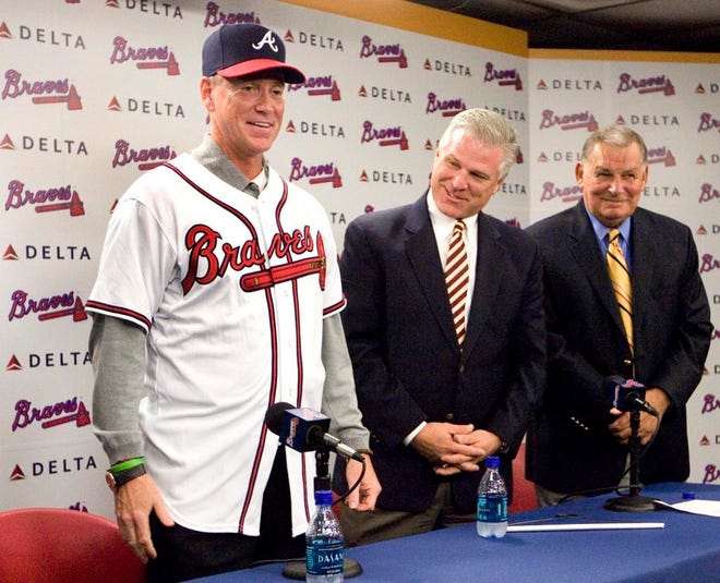Tom Glavine shows off his new jersey under the watchful eyes of general manager Frank Wren, and manager Bobby Cox, right, during a news conference in which the Atlanta Braves announced signing the pitcher to a one-year contract at Turner Field in this Nov. 19, 2007, file photo in Atlanta. Glavine walked through the doors to the Atlanta Braves clubhouse Friday, Feb.1 2008, and said it felt like home. (AP Photo/John Amis, file)