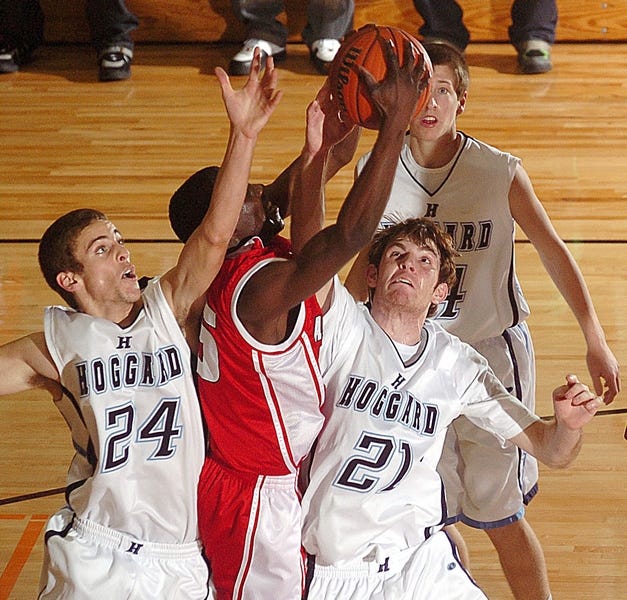 Jacksonville's Jeremy Hearst (55) reaches past Hoggard High School's Logan cain (24) and Ryan Abrams (21) for a rebound in basketball action during the semifinal round of the conference tournament Thursday Feb. 21, 2008. Staff Photo BY PAUL STEPHEN / STAR NEWS