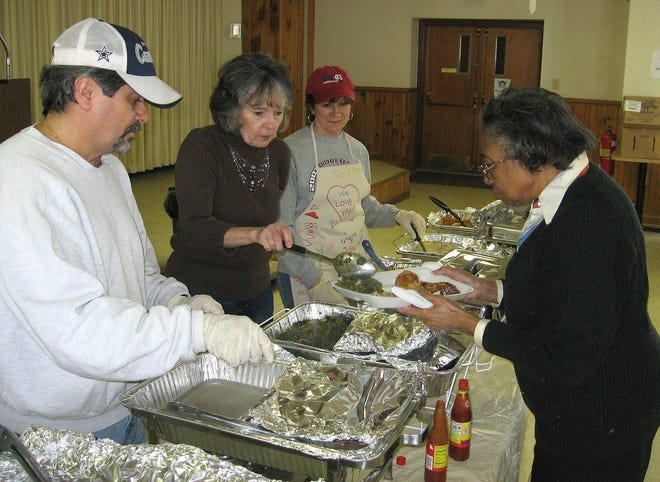 Norma Parish of Norwich, right, is served by, from left, Peter Ballaro, Carol Ballaro and Chris Jenkins, at the Norwich NAACP's annual Sweet Potato Festival on Saturday at St. Mary's Church.