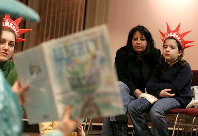 Heidi Pena and her granddaughter Alexandra Hernandez celebrate Presidents Day at the Saugus Library last wee, listening to Crystal Andrade of Liberty Tax Service ‘Lady Liberty’ read a special story about the presidents. Children’s librarian Natalie Layne, left, also listens to the presentation.