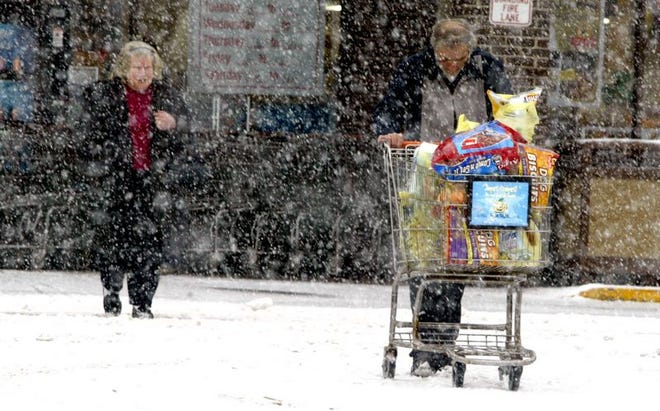 Harold and Stephanie Duffus of Livingston Manor rush to their car after stocking up on groceries at the Liberty ShopRite.