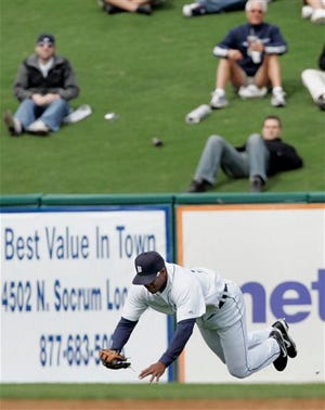 Detroit Tigers left fielder Jacque Jones tumbles after reaching out to snag a fly ball hit by New York Mets' Ruben Gotay for an out in the second inning of a spring training baseball game Wednesday, Feb. 27, 2008, in Lakeland, Fla. The Tigers came from behind to beat the Mets 4-2.