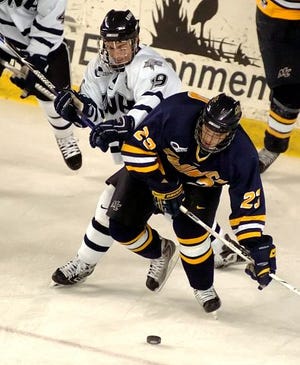 Merrimack's Chris Barton (23) holds off UNH's Brad Flaishans during the second period of Friday night's Hockey East game at the Whittemore Center.




Josh Gibney/ Democrat photo