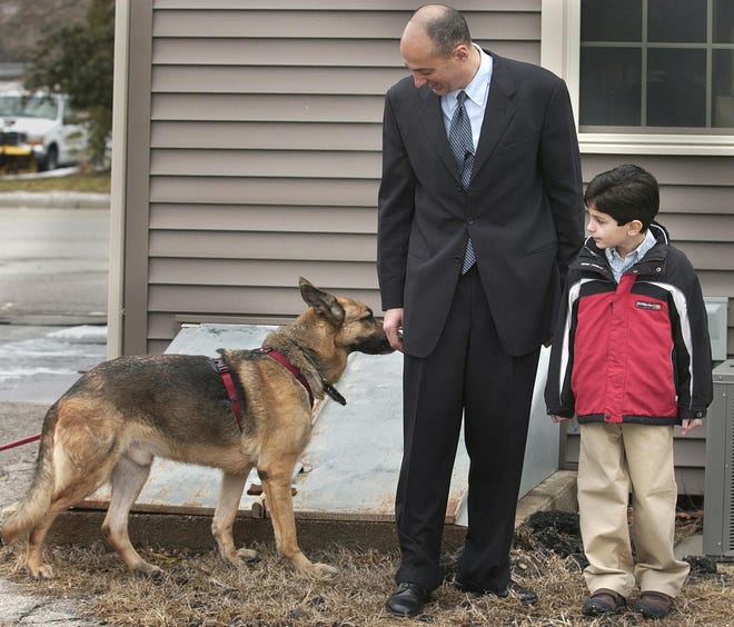 Dr. George Salem, a Braintree dentist, and Nicholas, a volunteer, participate in a demonstration in the use of saliva and possible DNA in tooth prints to find missing adults and children. German shepherd Mason picked up the scent of the “missing” 7-year-old boy.