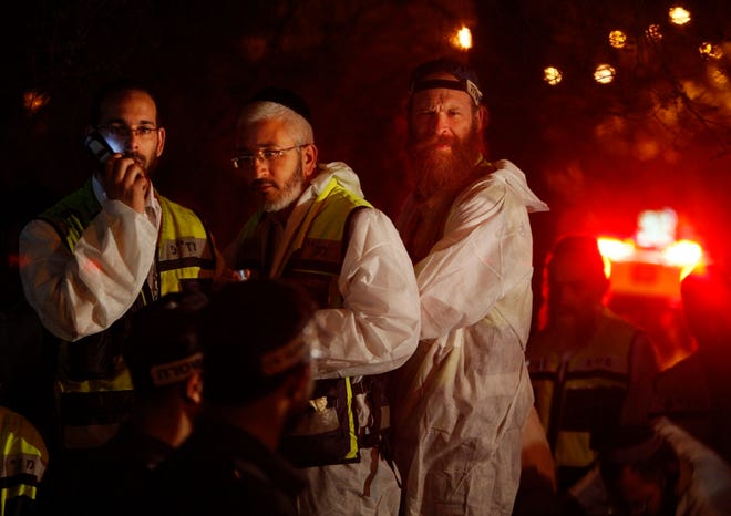 Israeli rescue workers wait at the site of a shooting in Jerusalem on Thursday. A gunman entered a study session at a rabbinical seminary and killed eight people before he was killed, according to authorities.