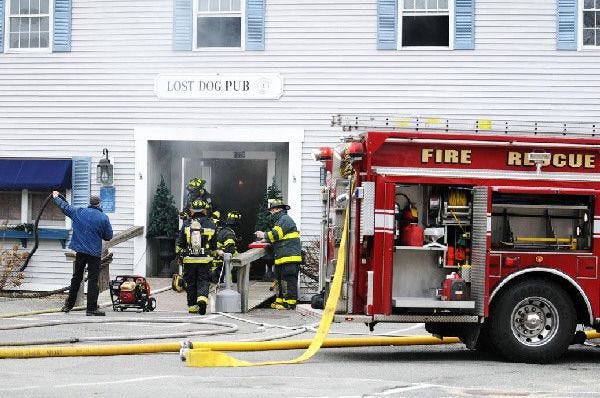 Firefighters from three towns respond to a fire at the Lost Dog Pub in Dennis yesterday. There was damage, but the building was saved.