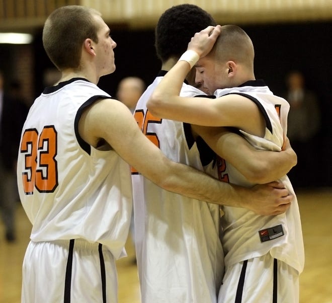 Marlborough senior guard Conner Flynn (right)is consoled by teammates Dan Imperato (left) and Keith Brown after the final whistle in the Division 1 Central title game.