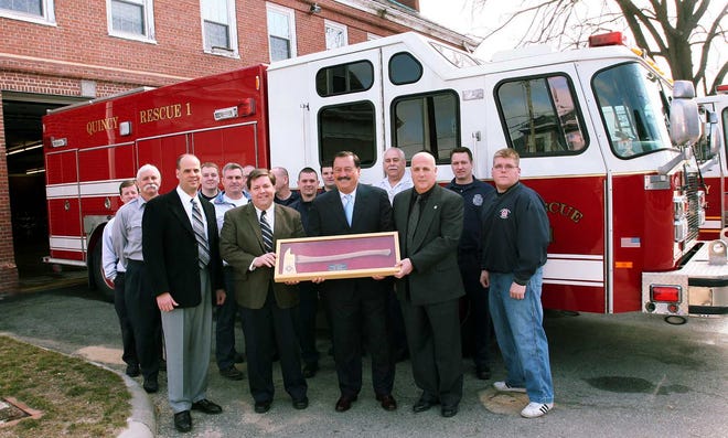 State Rep. Ron Mariano, center, with, from left, Fire Deputy Gary Smyth, Mayor Tom Koch and firefighters union president Ernie Arienti, holds an ax given by union members as thanks for his efforts to secure a rescue truck.
