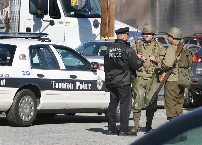 A Taunton police officer talks with extras dressed as World War II American soldiers on the set of Martin Scorsese’s “Ashecliffe,” being filmed at the Whittenton Mills complex in Taunton.