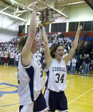 Cohasset’s Sammi Lehr, left, and Kayla Farren celebrate with the Division 4 South trophy after the Skippers defeated Millis, 42-30, at Braintree High.