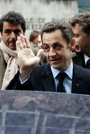 French President Nicolas Sarkozy waves as he walks out the polling station after casting his vote for Paris municipal election Sunday, March 9, 2008 in Paris. French local elections got under way Sunday, a test for conservative President Sarkozy, whose plummeting popularity has given an advantage to the left. People across France were voting in a first round to elect mayors, deputy mayors and municipal councilors. The final round is March 16.