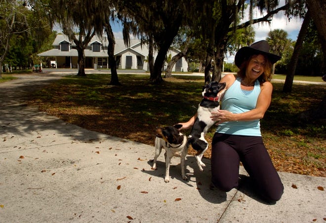 Beth Golden is greeted by her dogs Ripper and Dixie at her seven-acre home on Waterline Road, near State Road 64 and Rye Road in East Manatee County. Golden and her neighbors fear that increased traffic from a proposed 119-home subdivision on 78 acres nearby will interfere with the area's country lifestyle.