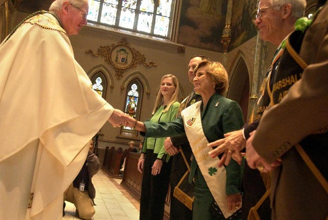 Bishop J. Kevin Boland accepts the St. Patrick's Day Mass offerings from Parade Grand Marshall Frank Rossiter and his wife, Glenda, who is shaking the bishop's hand. (Carl Elmore/Savannah Morning News)