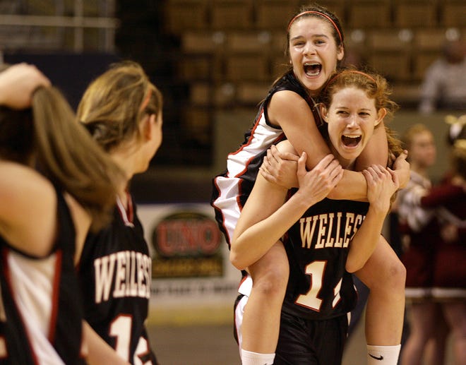 Wellesley's Mary Louise Dixon jumps on the back of teammate Lindsay Sydness after the Raiders won the Div. 2 state championship.