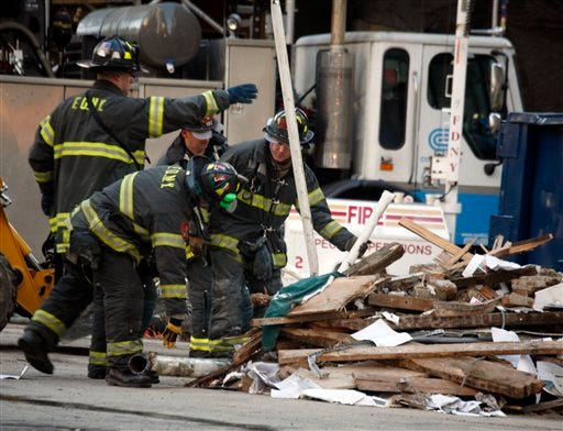 Fire fighters move debris at the scene of the crane collapse on the east side of Manhattan in New York on Monday, March 17, 2008. Three people remained missing after the crane crashed down on Saturday killing at least four workers, injuring dozens and damaging six buildings.