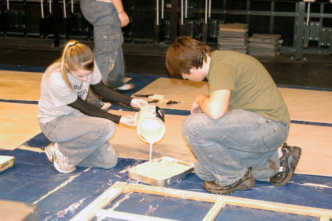Sophomore Ben Klaus, right, waits while another student pours paint in a pan. Washington Community High School students spent the day Feb. 9 constructing sets for the spring production, "A Night of One Acts: A Montage of Absurd Realities."