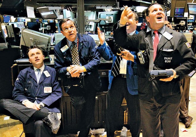 Traders on the floor of the New York Stock Exchange watch as the Fed board rate decision is announced Tuesday.
