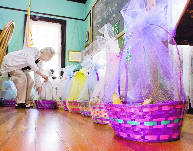 MAVIS CARMICHAEL<0x00A0>lines up finished Easter baskets at the Fort Meade Historical Museum on Tuesday in Fort Meade. Baskets were created by volunteers and will be given to 22 Fort Meade 90-plus-year-olds for Easter.